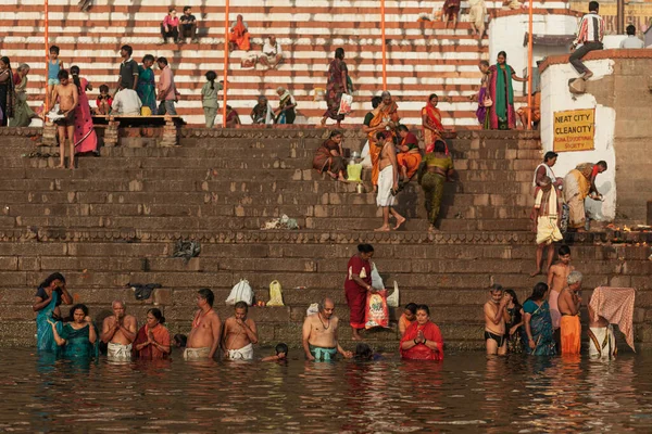 VARANASI, INDIA - NOVEMBER 12, 2014: Dozens of hindu devotees perform spread all over ghats to conduct morning prayer on the banks of the Ganges River - Stock-foto