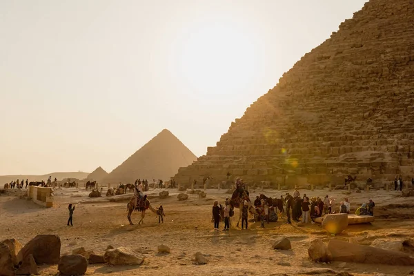 CAIRO, EGYPT- NOVEMBER 17, 2018: 여행자들 이 기자의 피라미드 근처에서 낙타를 타고 다닌다 — 스톡 사진