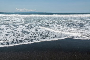 Volkanik plajda köpüklü dalgalar, Bali, Endonezya