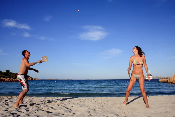 若いカップルはビーチでテニスをしています。. — Stock fotografie