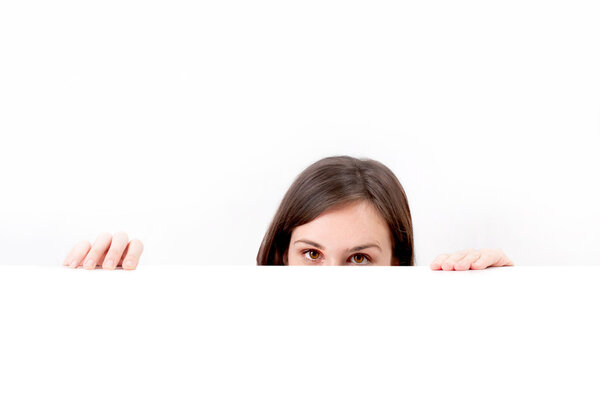 Woman peeping over white background.