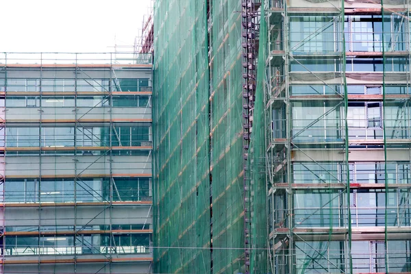 Treppe und Baugerüst auf einer Baustelle, mit Gitternetzen abgedeckt. — Stockfoto