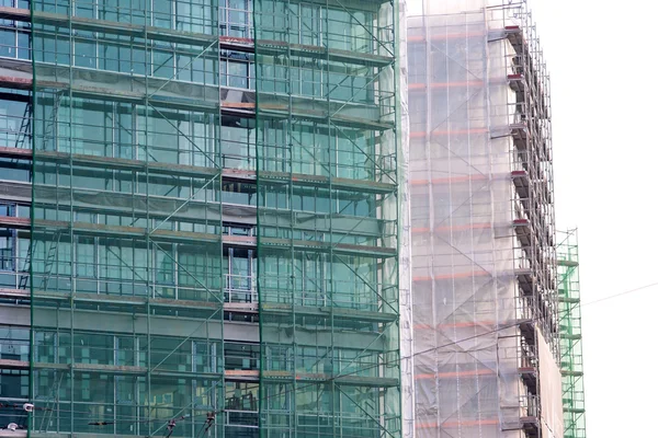 Treppe und Baugerüst auf einer Baustelle, mit Gitternetzen abgedeckt. — Stockfoto