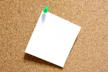 Yapışkan Not corkboard üzerinde yeşil raptiye ile.
