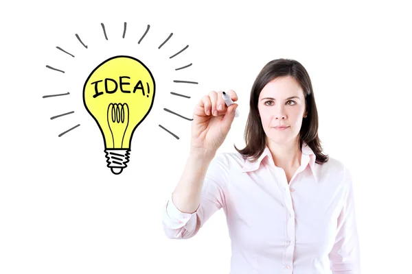 Young business woman drawing a light bulb. Isolated on white. — Stock Photo, Image