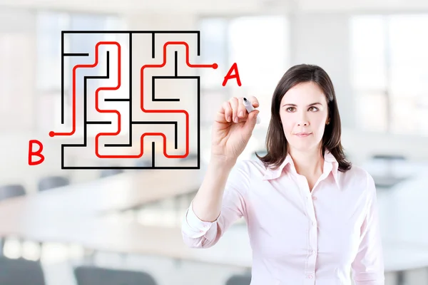 Young businesswoman finding the maze solution writing on the whiteboard. Office background. — Stock Photo, Image