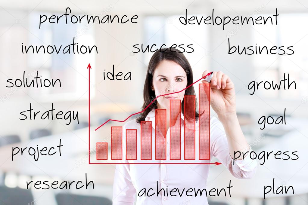 Young business woman writing growth graph with business related text. Office background.