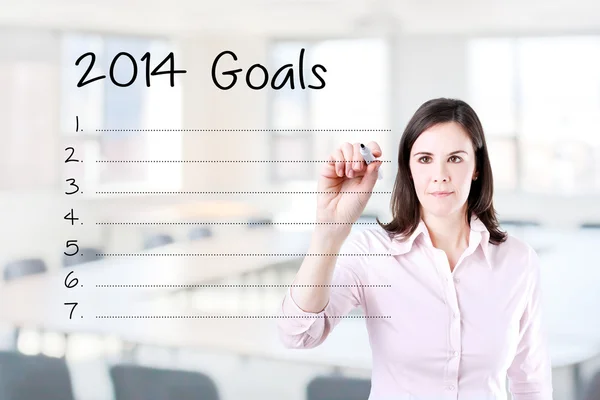 Business woman writing blank 2014 goals list. Office background. — Stock Photo, Image