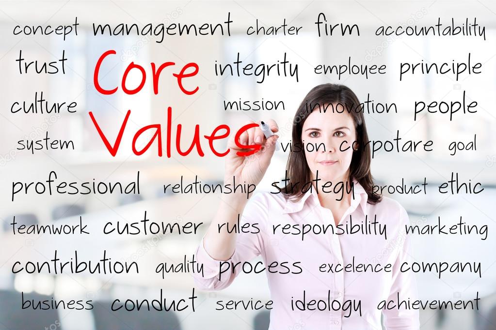 Young business woman writing concept of core values. Office background.