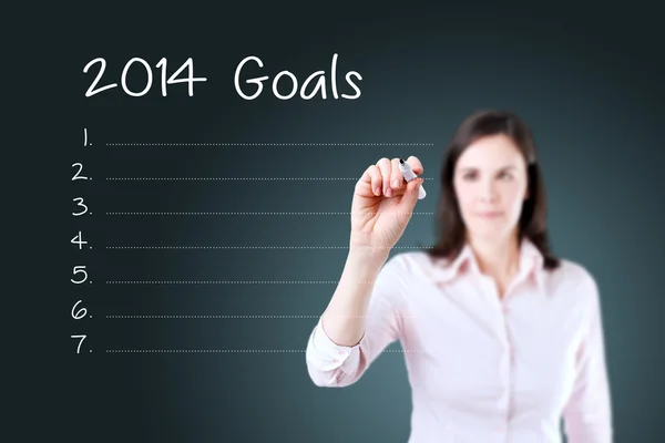 Donna d'affari che scrive lista di obiettivi 2014 vuota. Fondo blu . — Foto Stock