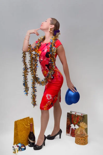 Menina bonita celebra o Natal e Ano Novo com um presente e chapéu de mascarada em suas mãos — Fotografia de Stock