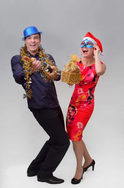 Maskeli balo şapkalı adam ve bir kadın maskeli eller şampanya ve Hediyelik tuttu ve Noel ve yeni yıl tatili zevk