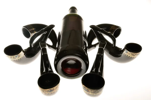 Натюрморт с винной бутылкой и декоративными рогами — стоковое фото