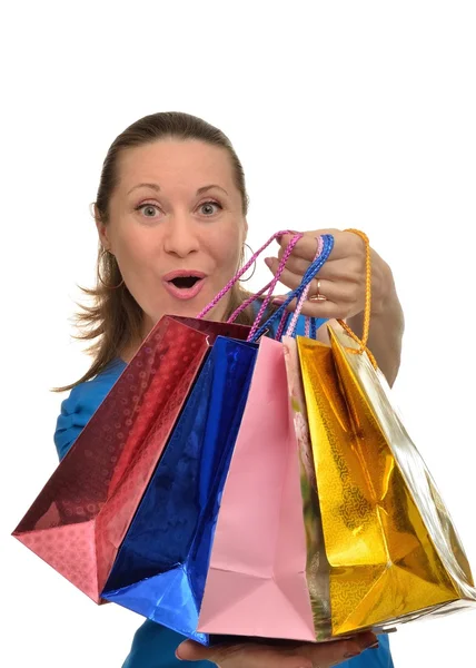 Kvinna med färgglada paket i händer jublar inköp — Stockfoto