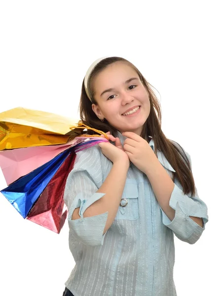 Teen girl with multicolored packages in hands rejoices purchases — Stock Photo, Image