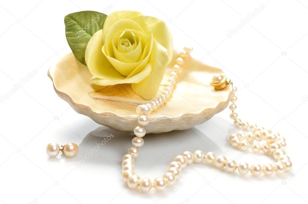 Pearl necklace lies at the a seashell