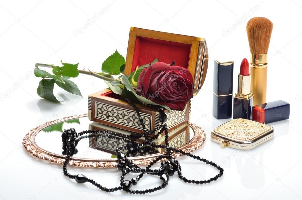 Women's jewelry, perfumes, cosmetics and flowers in still life