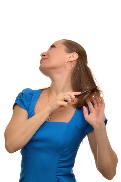 Женщина в синем платье расчесывает волосы — стоковое фото
