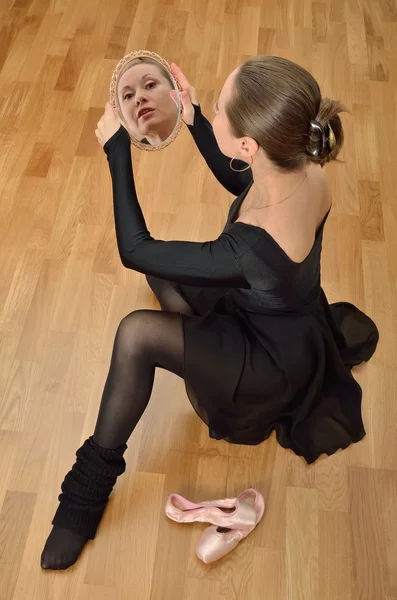 Bailarina em preto olha no espelho — Fotografia de Stock