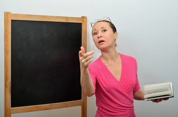 Woman teacher invites the pupil to blackboard holding out his hand — Stock Photo, Image