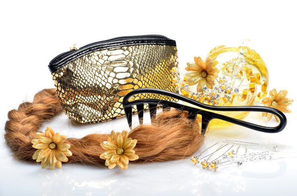 Artificial hair and accessories for women hairstyles, cosmetic bag and a comb in still life