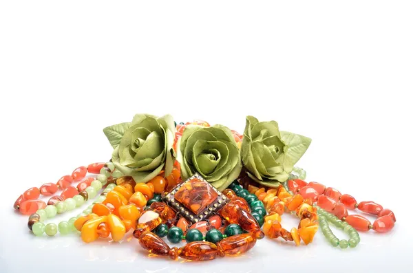 Women's jewelry - different colored beads, brooch and flowers roses in still life — Stock Photo, Image