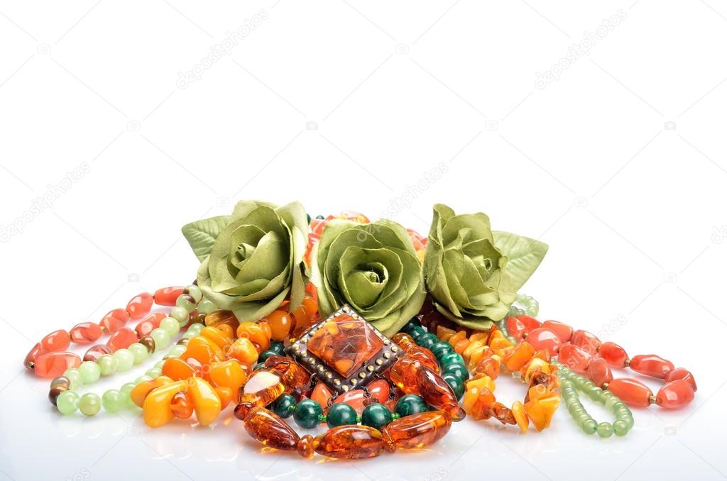 Women's jewelry - different colored beads, brooch and flowers roses in still life