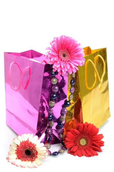 Bolsas de regalo coloridas, cuentas y flores para el bodegón de vacaciones —  Fotos de Stock
