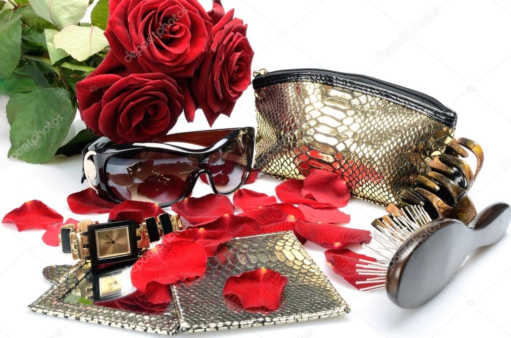 A Red rose petals, women's accessory Handbag, sunglasses, comb, mirror, watch. in still life