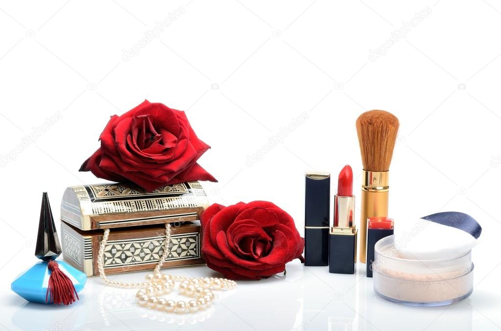 Cosmetics, perfumes, pearl beads, jewelry box and roses in a still life