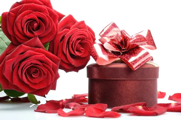 Presentask, kronblad och en bukett röda rosor — Stockfoto
