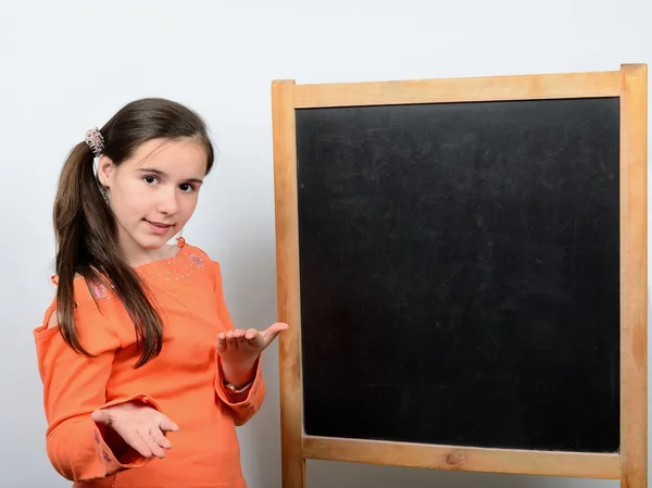 Έφηβος κορίτσι στέκεται στο μαυροπίνακα στο σχολείο — Φωτογραφία Αρχείου