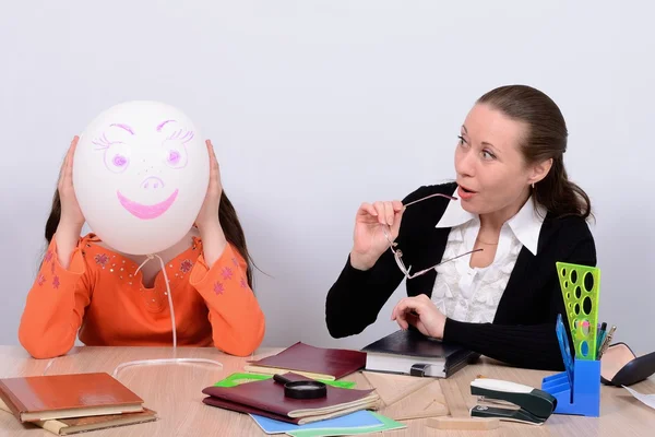 Child with teacher joked, showing cheerful balloon with a smile — Stock Photo, Image