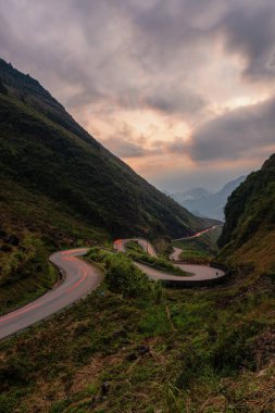 Gün batımında Vietnam dağları arasında Ha Giang virajı yolu