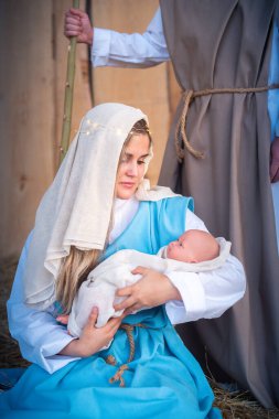 Meryem Ana İsa 'yı geleneksel doğum sahnesinde kucağında tutuyor.