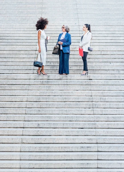 Collègues parlant au milieu d'un escalier de granit — Photo