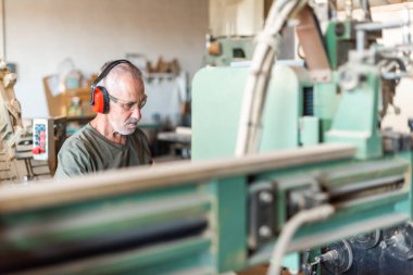 Erkek çalışan endüstriyel bir fabrikada çalışıyor.