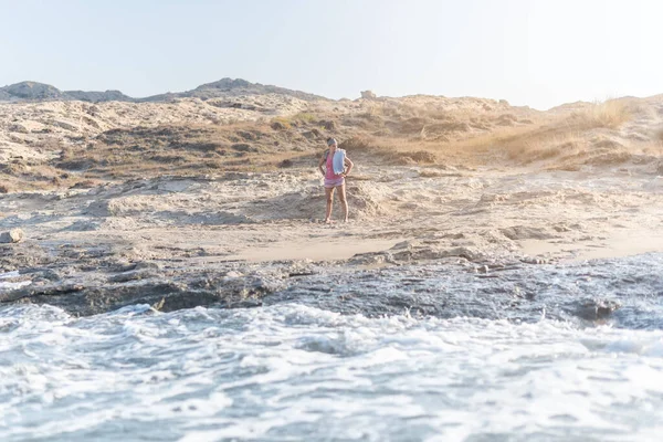 Mulher na praia de areia perto do mar espumoso — Fotografia de Stock