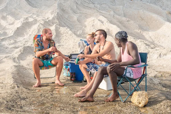 Vier junge Erwachsene amüsieren sich am Strand — Stockfoto