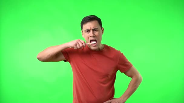 Muž v červeném tričku čistí zuby — Stock video