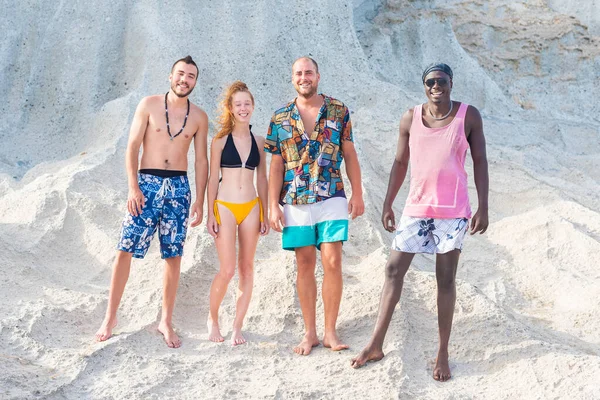 Amizade de quatro jovens de pé em uma praia rochosa — Fotografia de Stock