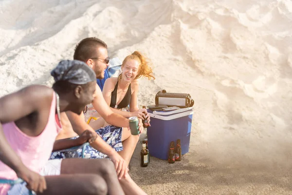 Drei Freunde feiern am Strand und lachen beim Trinken — Stockfoto