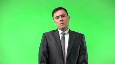 Sıkılmış genç iş adamı yüzünü kapatıyor ve kameraya bakıyor.