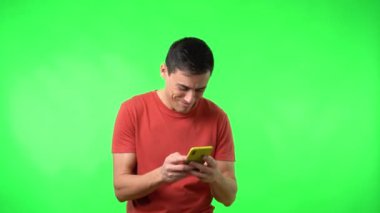 Akıllı telefondan mesaj alan ve mutlu bir şekilde gülümseyen neşeli adam.