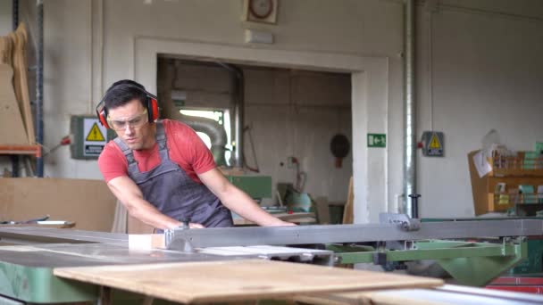 Carpintero de corte de madera en la máquina de sierra deslizante — Vídeos de Stock