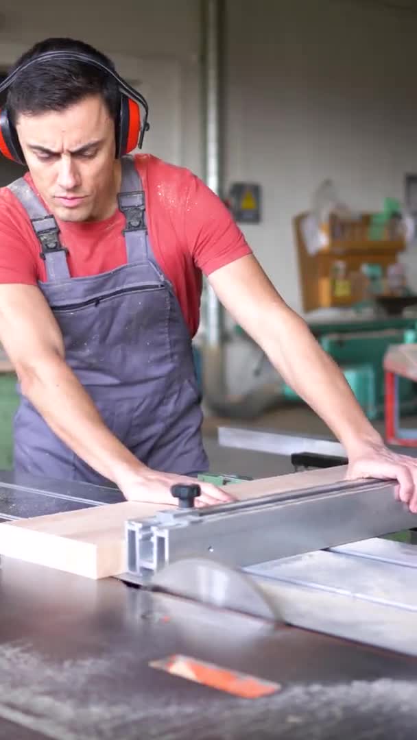 Tablón de corte de carpintero con sierra de mesa en taller — Vídeos de Stock