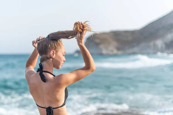 Молодая женщина делает хвостик на пляже — стоковое фото