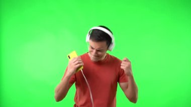 Adam kulaklıklardan müzik dinlerken mutlu bir şekilde dans ediyor.