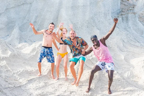 Vier junge Erwachsene winken und bewegen sich im Badeanzug — Stockfoto