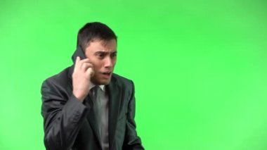 Takım elbiseli neşeli adam telefonda konuşuyor.